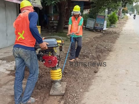 Pekerja PT Melinda Pratama Putra memadatkan bahu jalan, bekas galian pipa menggunakan stamper