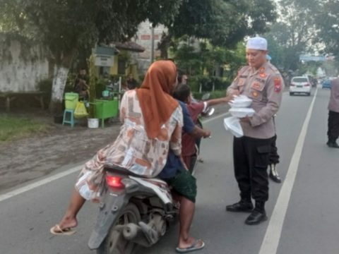 Kapolsek Puger berikan tajil Kepada masyarakat yang kebetulan melintasi jalan di depan Kantor Mapolsek Puger. (08/04/2023).