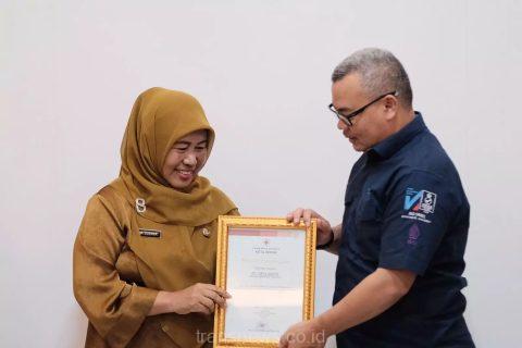 Pj.Sekda Kota Depok, Nina Suzana menyerahkan penghargaan kepada Dirut Tirta Asasta, M.Olik Abdul Holik.